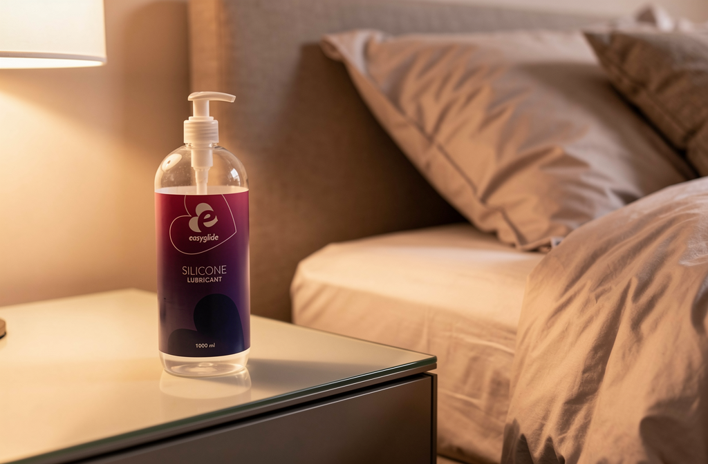 Flacon de lubrifiant intime posé sur une table de chevet moderne dans une chambre romantique.